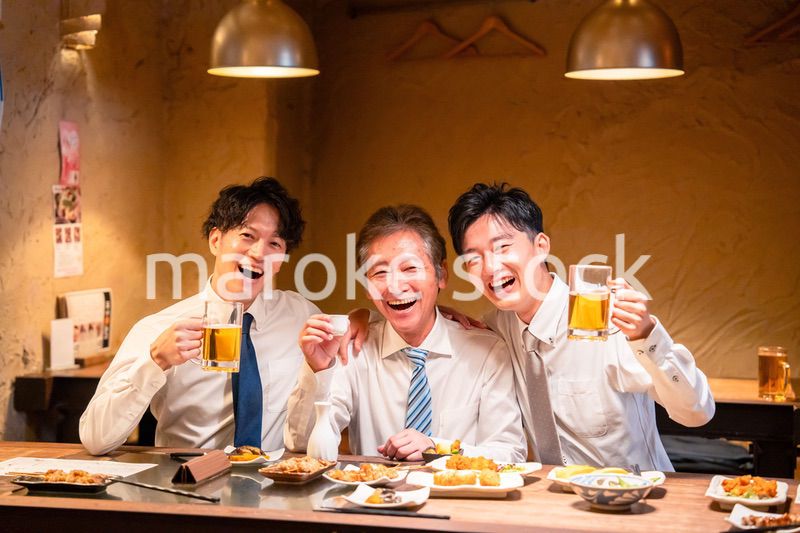 上司と肩を組みながら居酒屋で飲むサラリーマン