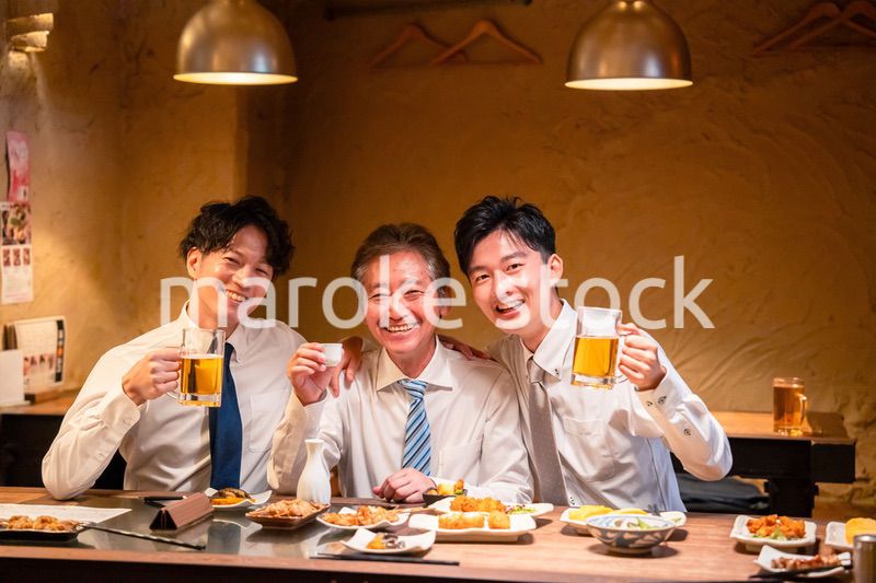 上司と肩を組みながら居酒屋で飲むサラリーマン