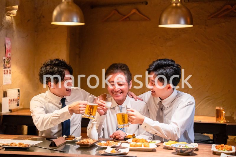 上司と肩を組みながら居酒屋で飲むサラリーマン
