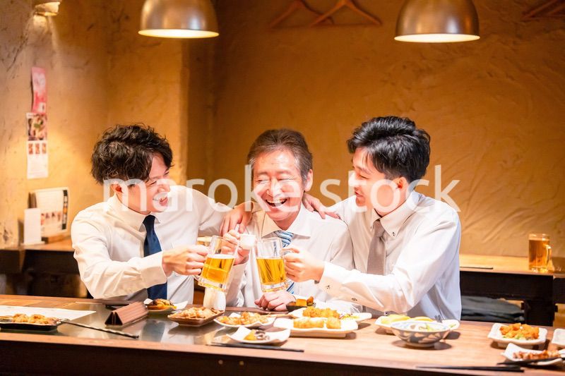 上司と肩を組みながら居酒屋で飲むサラリーマン