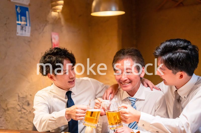 上司と肩を組みながら居酒屋で飲むサラリーマン