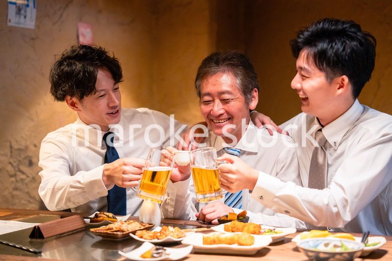 上司と肩を組みながら居酒屋で飲むサラリーマン