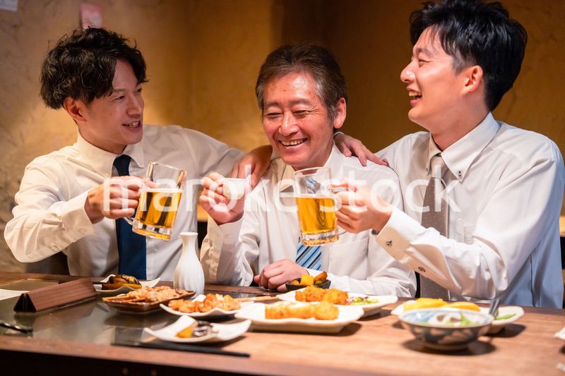 上司と肩を組みながら居酒屋で飲むサラリーマン