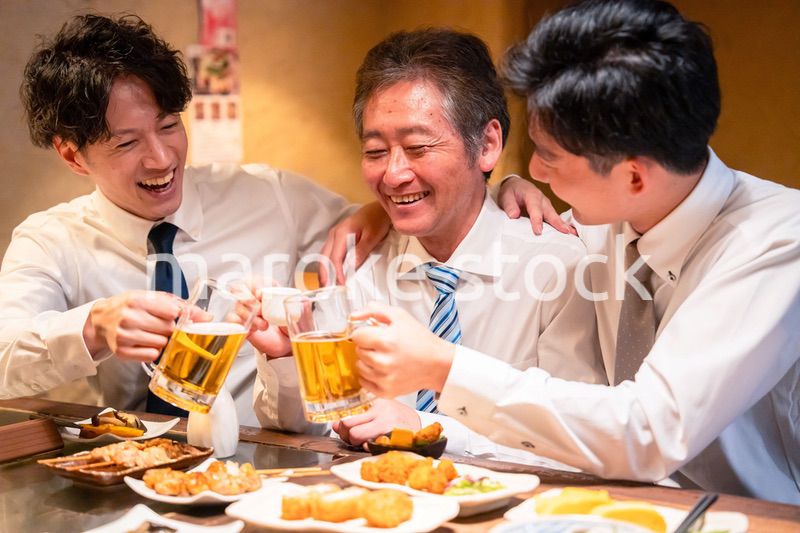 上司と肩を組みながら居酒屋で飲むサラリーマン