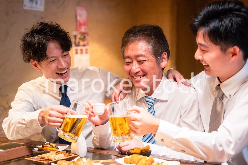上司と肩を組みながら居酒屋で飲むサラリーマン