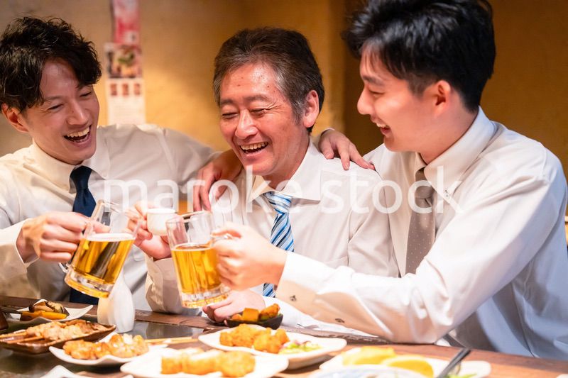 上司と肩を組みながら居酒屋で飲むサラリーマン