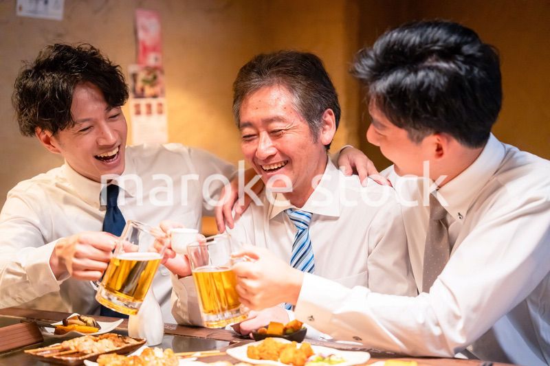 上司と肩を組みながら居酒屋で飲むサラリーマン