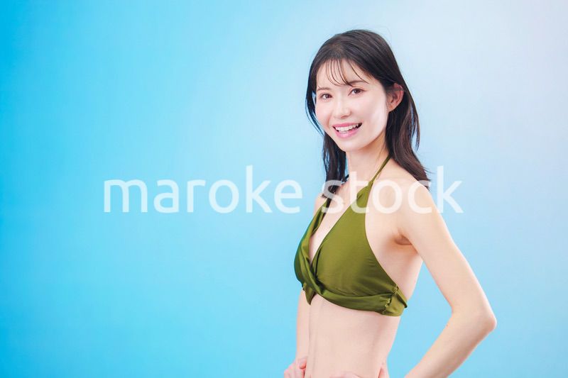 水着を着て夏を満喫する女性（水色背景）