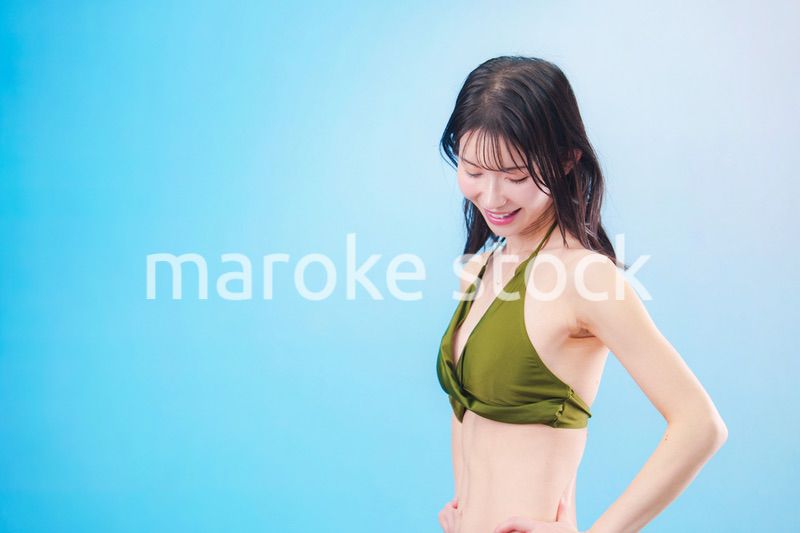 水着を着て夏を満喫する女性（水色背景）