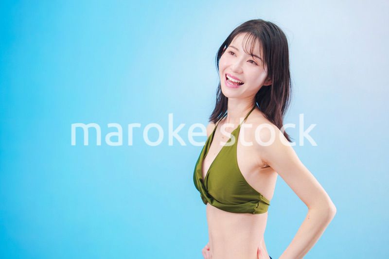 水着を着て夏を満喫する女性（水色背景）
