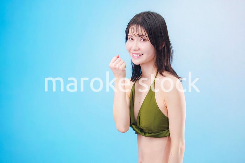 水着を着て夏を満喫する女性（水色背景）