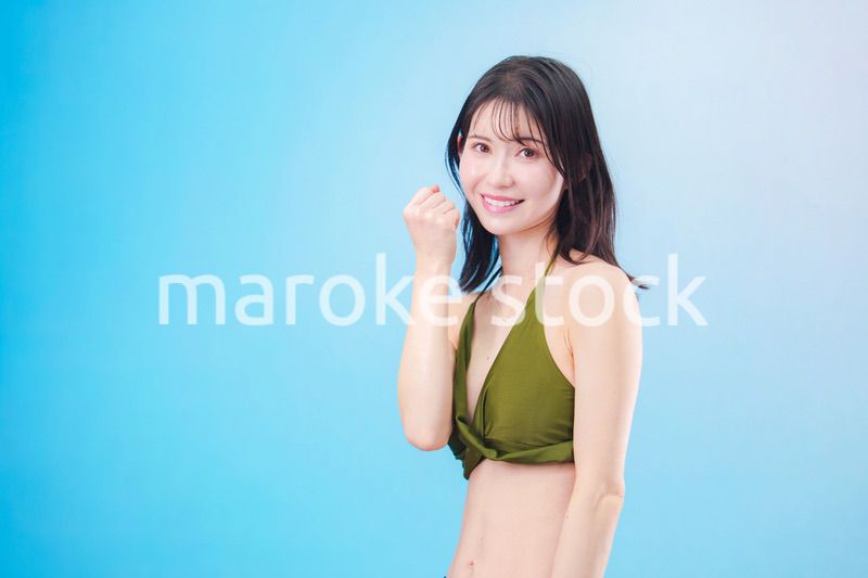 水着を着て夏を満喫する女性（水色背景）