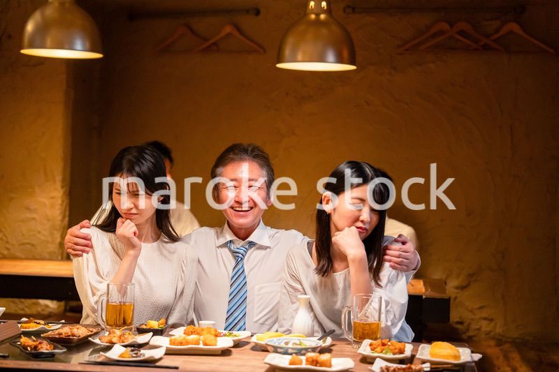 宴会の席で女性と肩を組むビジネスマン