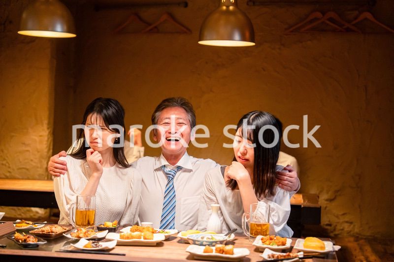 宴会の席で女性と肩を組むビジネスマン