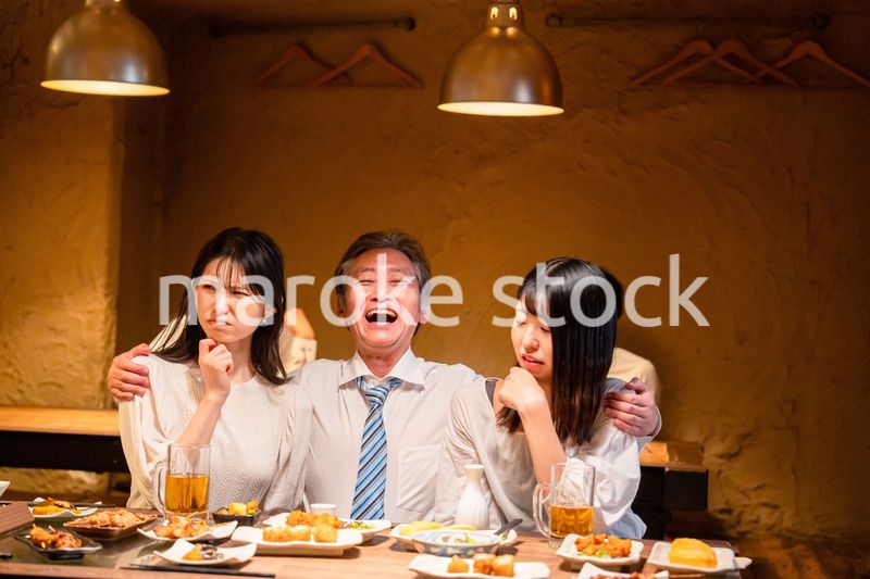 宴会の席で女性と肩を組むビジネスマン