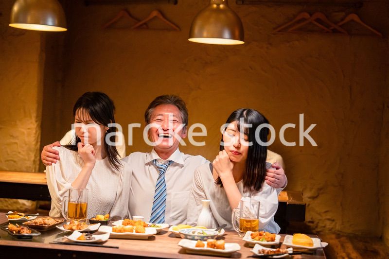 宴会の席で女性と肩を組むビジネスマン