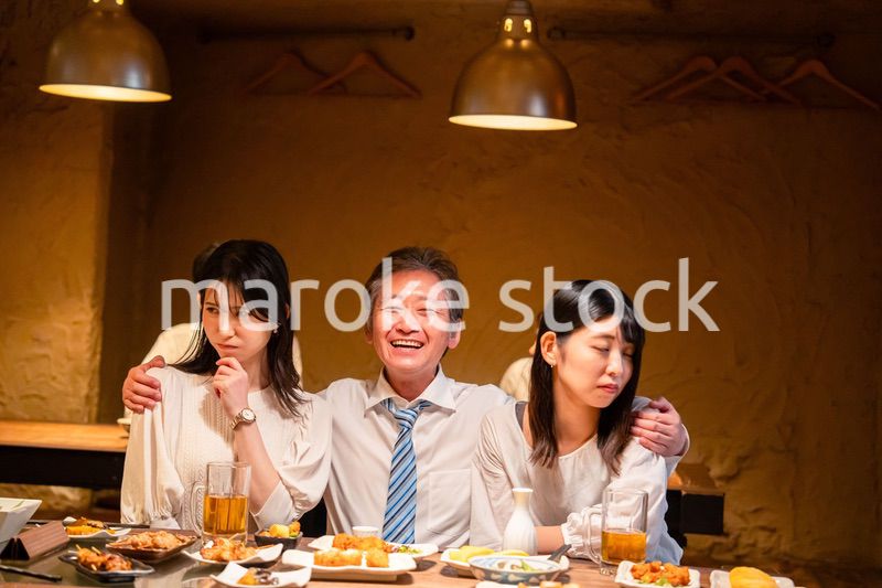 宴会の席で女性と肩を組むビジネスマン