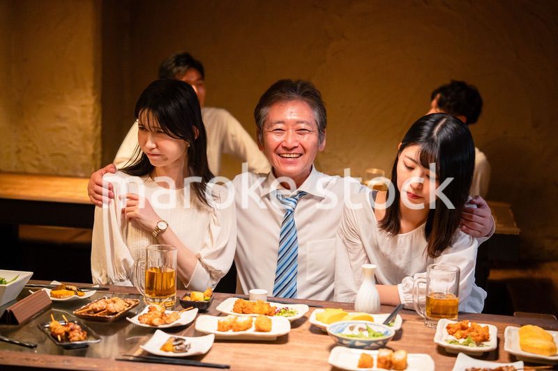 宴会の席で女性と肩を組むビジネスマン