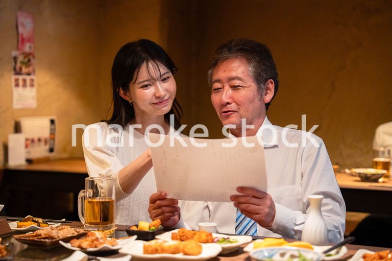 若い女性と二人でお酒を飲む男性