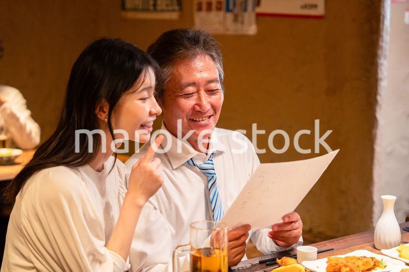 若い女性と二人でお酒を飲む男性