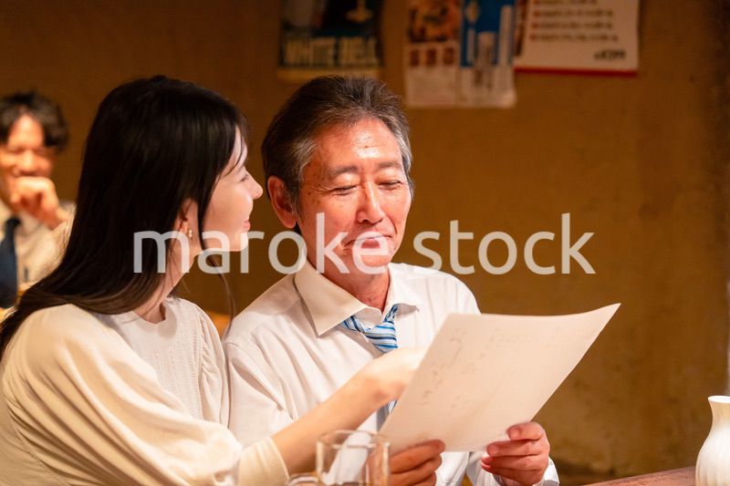 若い女性と二人でお酒を飲む男性