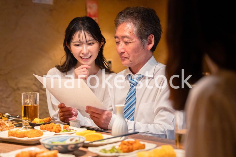 若い女性と二人でお酒を飲む男性