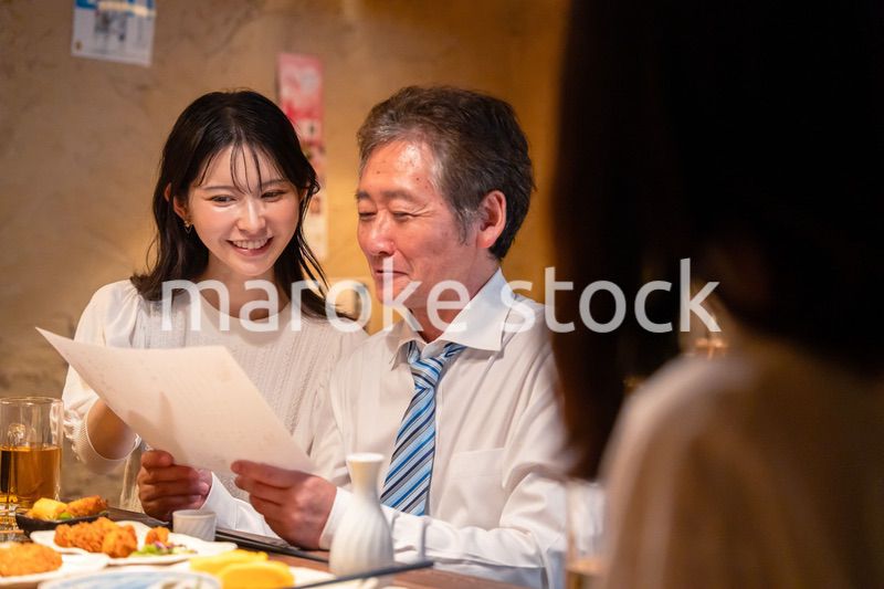 若い女性と二人でお酒を飲む男性