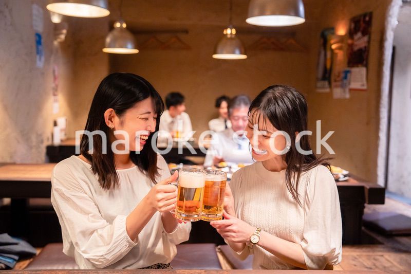 居酒屋で女子会をする二人の女性
