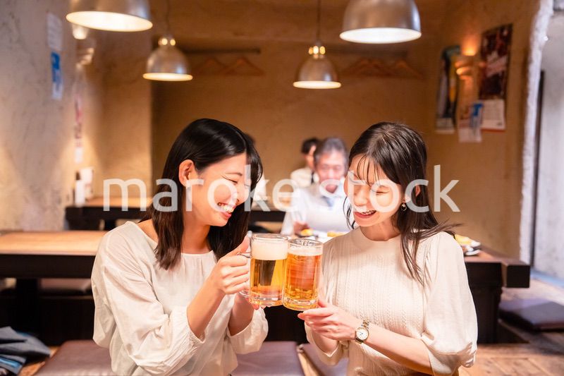 居酒屋で女子会をする二人の女性