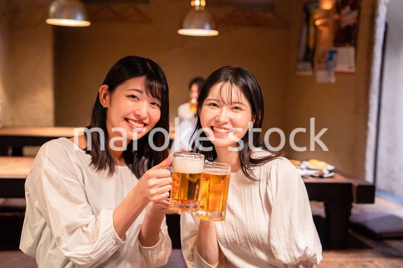 居酒屋で女子会をする二人の女性