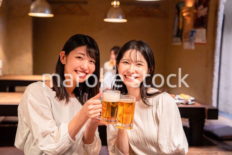 居酒屋で女子会をする二人の女性