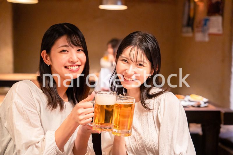 居酒屋で女子会をする二人の女性