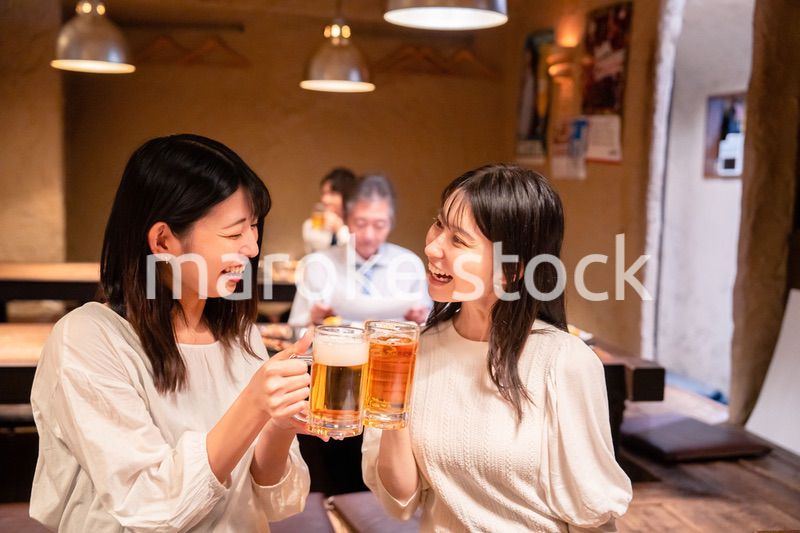居酒屋で女子会をする二人の女性