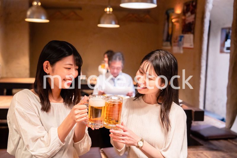 居酒屋で女子会をする二人の女性