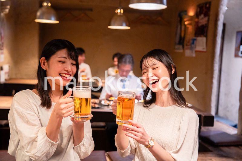 居酒屋で女子会をする二人の女性
