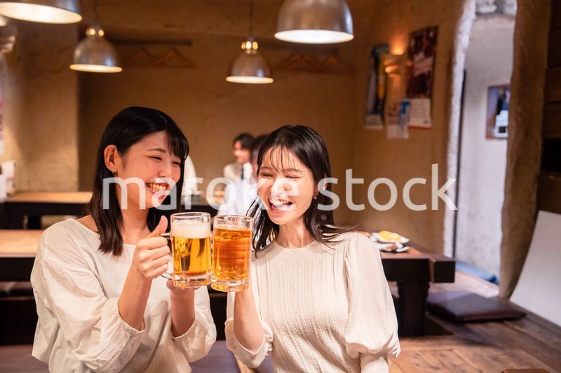 居酒屋で女子会をする二人の女性