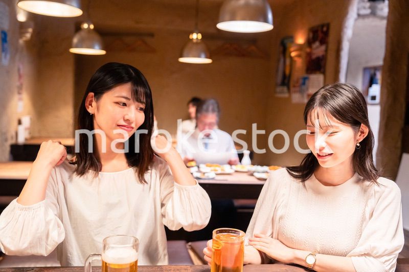 居酒屋で女子会をする二人の女性
