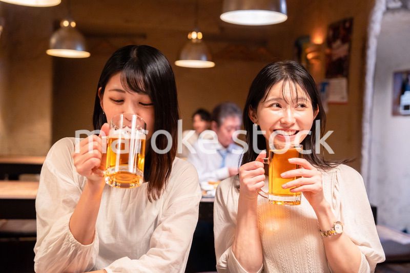 居酒屋で女子会をする二人の女性