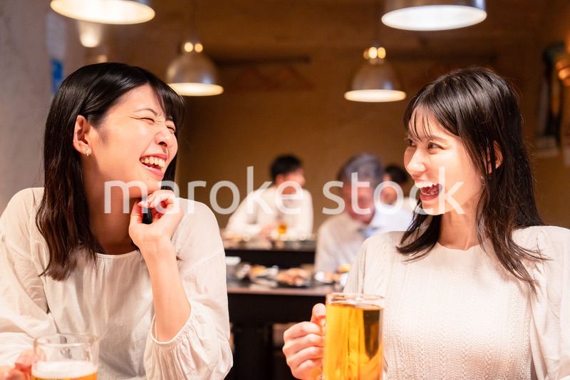 居酒屋で女子会をする二人の女性
