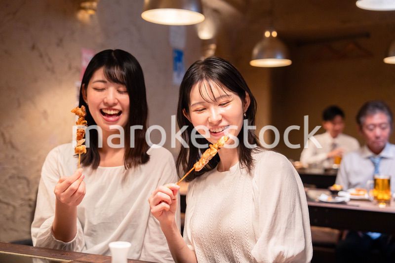 居酒屋で女子会をする二人の女性
