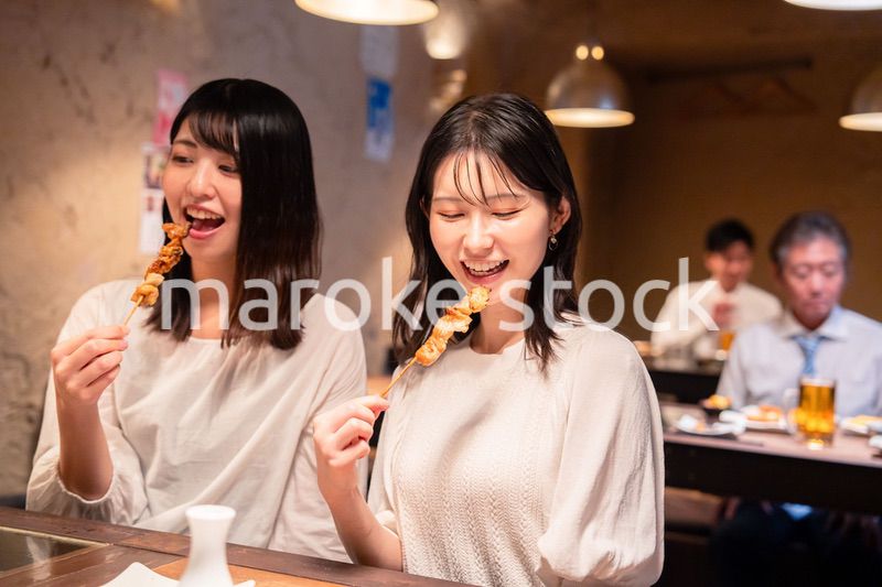 居酒屋で女子会をする二人の女性