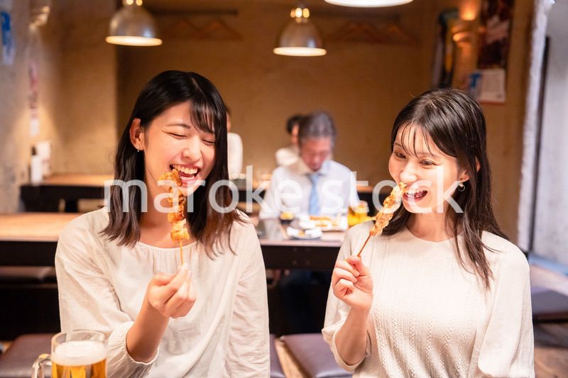 居酒屋で女子会をする二人の女性