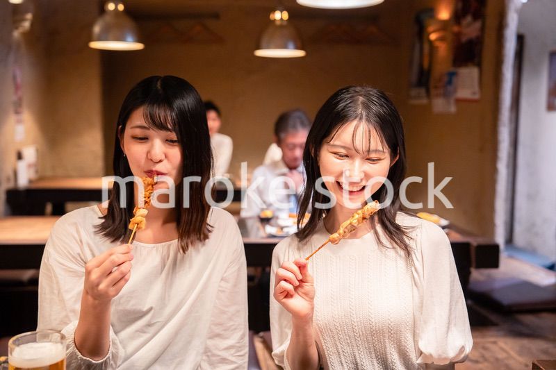 居酒屋で女子会をする二人の女性