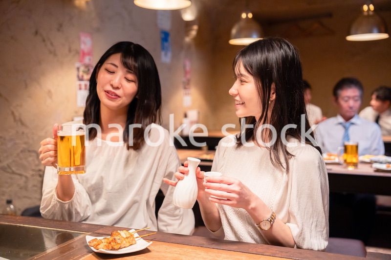 居酒屋で女子会をする二人の女性