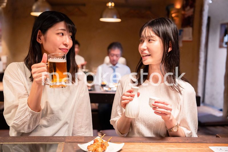 居酒屋で女子会をする二人の女性