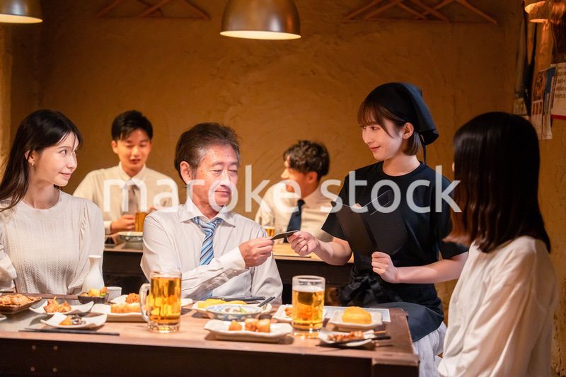 居酒屋でキャッシュレス決済をする男性客