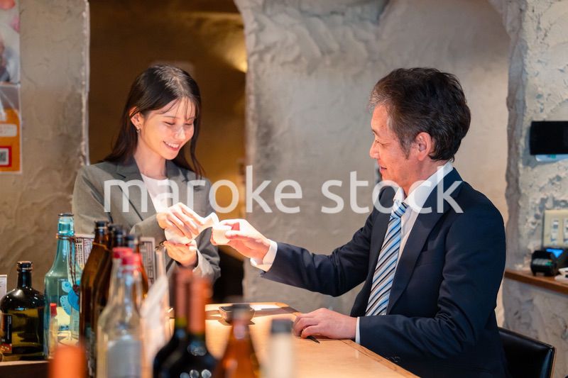 女性とお酒を飲むシニアのビジネスマン
