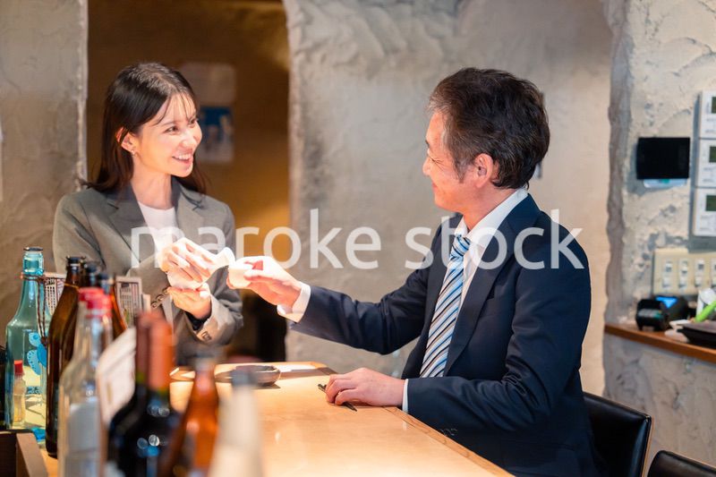 女性とお酒を飲むシニアのビジネスマン