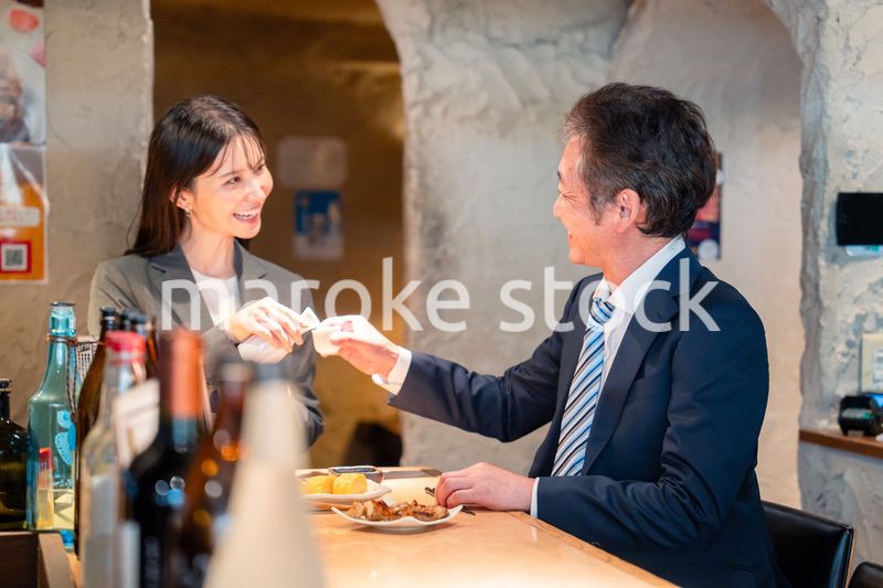 女性とお酒を飲むシニアのビジネスマン