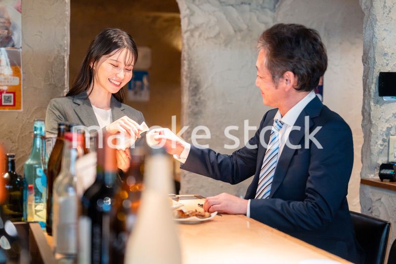 女性とお酒を飲むシニアのビジネスマン